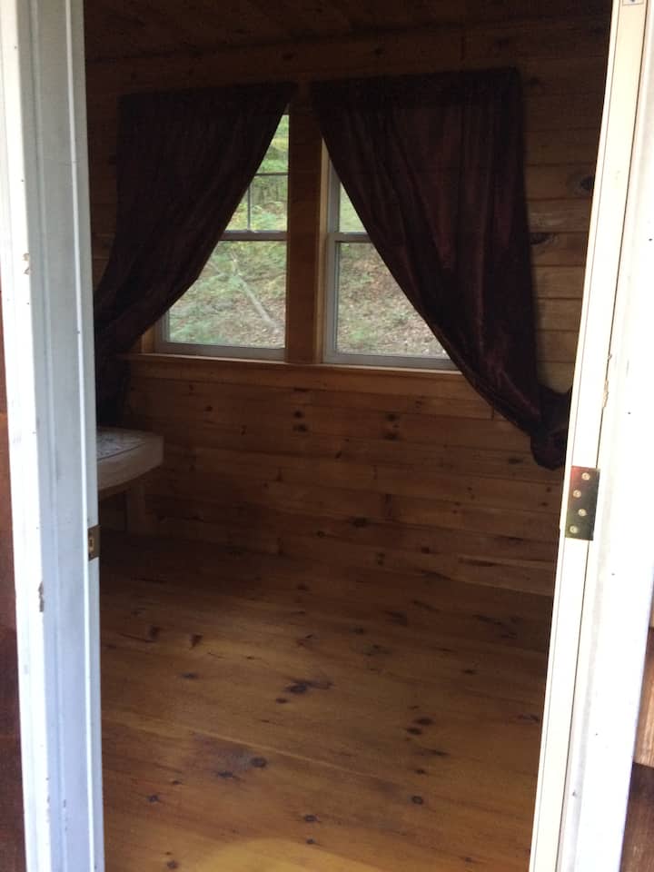 Knotty pine interior. 3 out of  5 windows have screens.  