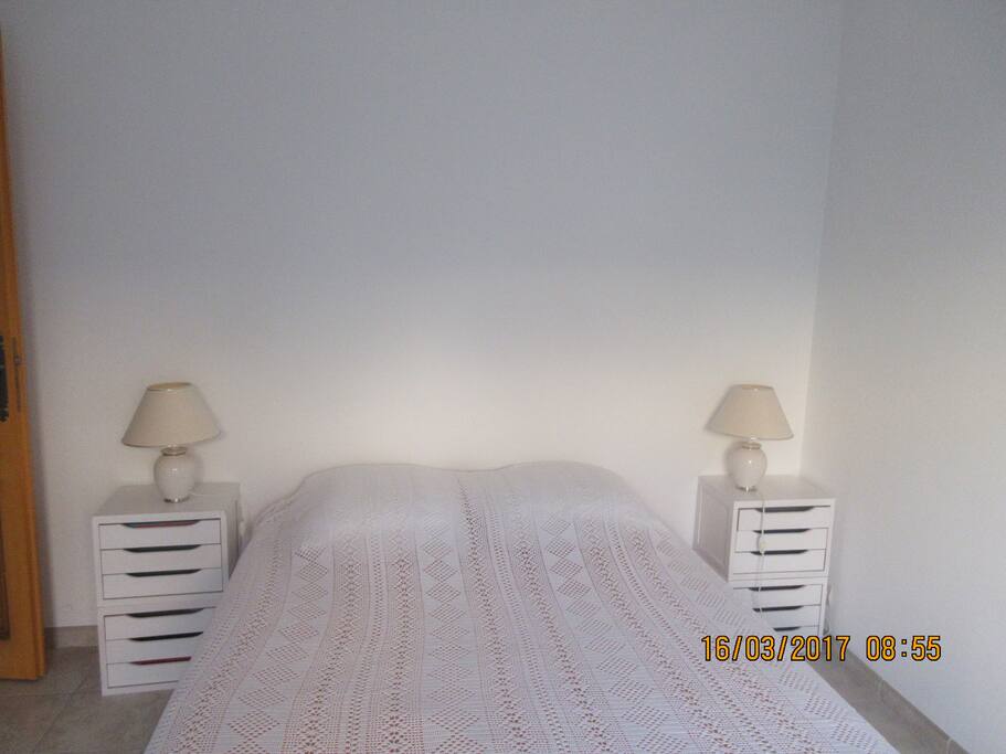 Chambre n°2 avec porte-fenêtre donnant sur un jardinet.