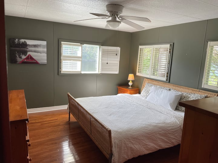 Grande chambre principale avec un lit King Size, vue sur le lac et dressing