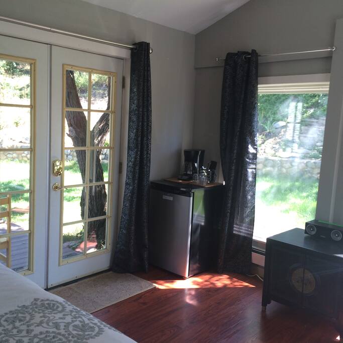 French doors leading into the backyard. Mini fridge and coffee maker.