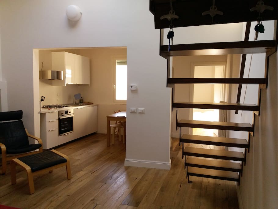 Living, kitchen and steps to gallery