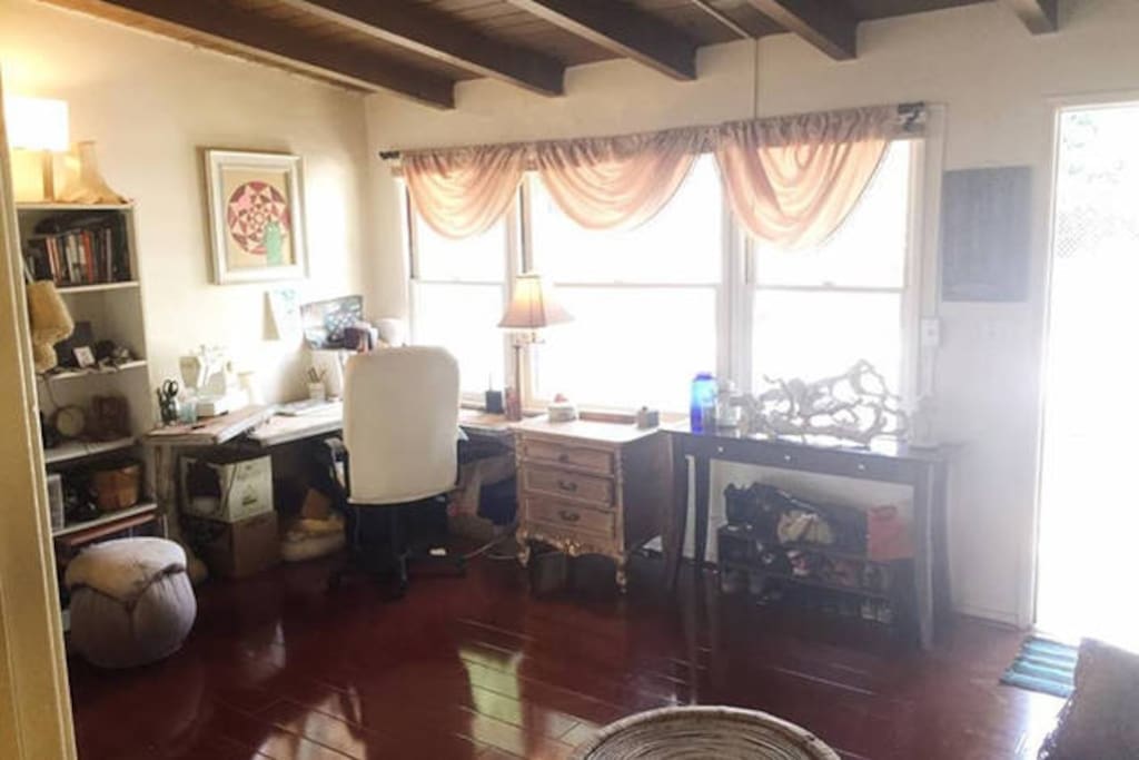 Living Room. Desktop workspaces, hardwood floors, floor to ceiling mirrors, cozy couch, large windows, sound system, pull up bar in hallway. Plenty of floor space in front of mirrors for dance/yoga/pilates/exercise activities