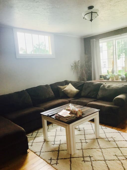 Living room beautifully decorated with hand crafted wood products pulling in the original refinished hardwood floor. Large comfy couch seats many people and can easily be used to sleep on. TV has RoKu stick, no cable.