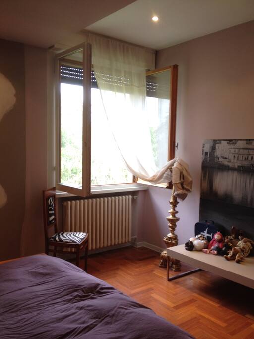 camera da letto matrimoniale con finestra affacciata sul parco