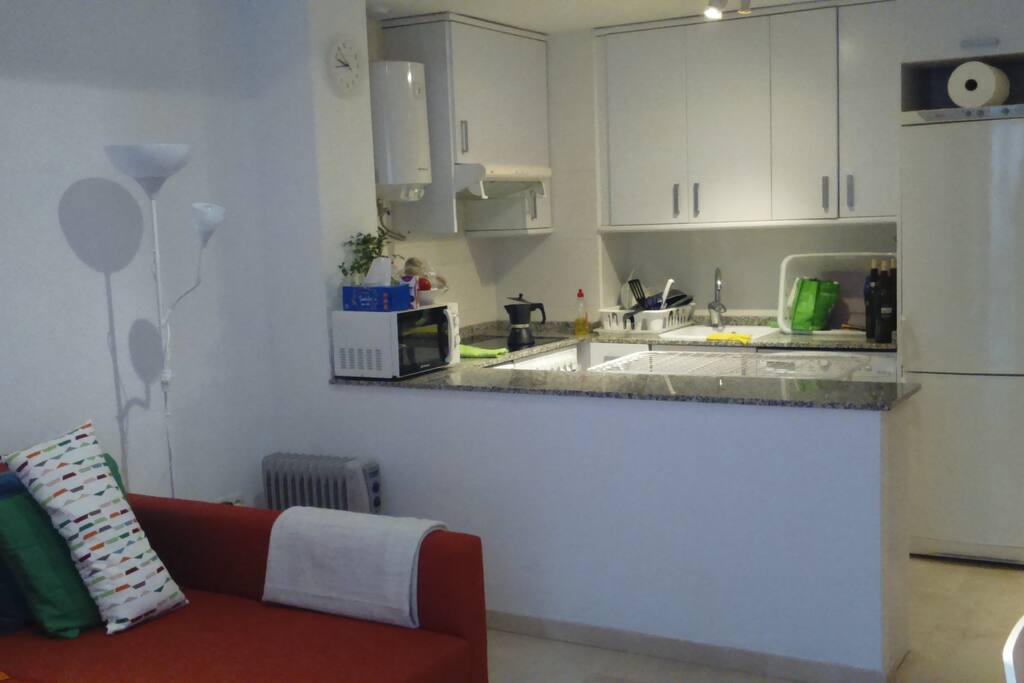 cocina integrada en salón con todo lo necesario, incluso lavaplatos