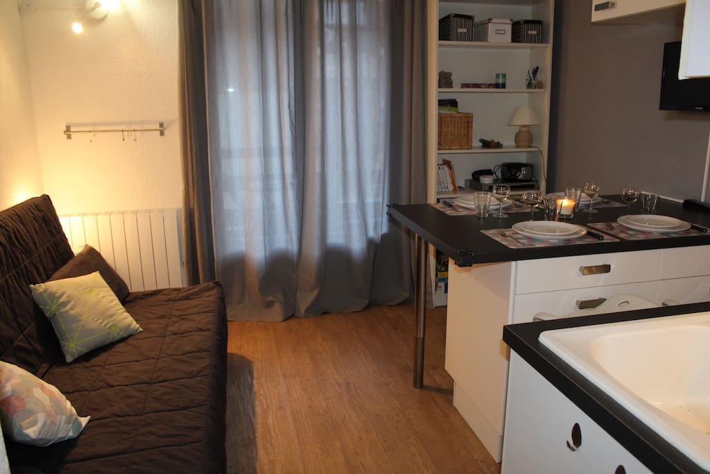 Séjour avec canapé convertible (BZ), porte-fenêtre donnant sur le balcon et coin repas