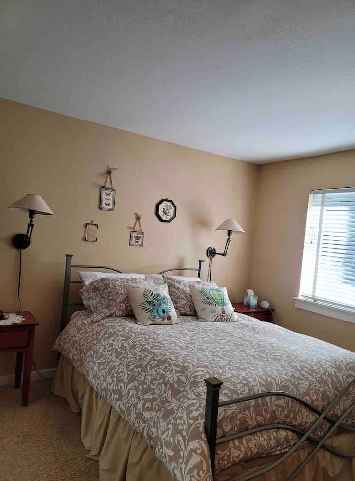 Dhoma e parë e gjumit në katin e poshtëm, krevat dopio "queen" me banjë en suite.