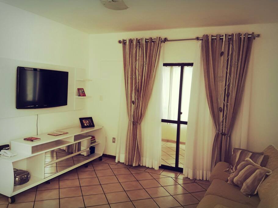Sala com TV e sofá disponível para os hóspedes