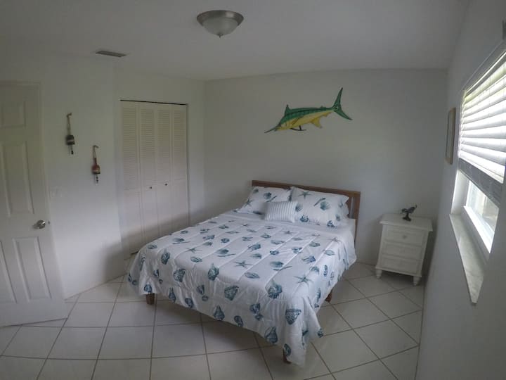 Habitación de pez con espadas con cama tamaño queen con armario grande con cómoda con espejos, mesita de noche y lámpara