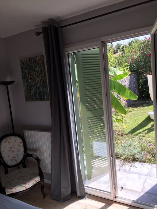 La porte fenêtre de la chambre donne sur le jardin