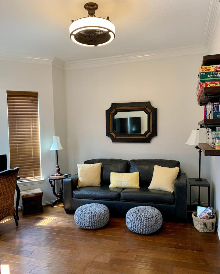Front den includes a desk for a workspace with a window view, a wall mounted TV with Amazon Firestick, DVD player with DVDs, Playstation 3 console and games,  assorted board games, sleeper sofa with curtains over both entries for additional privacy.