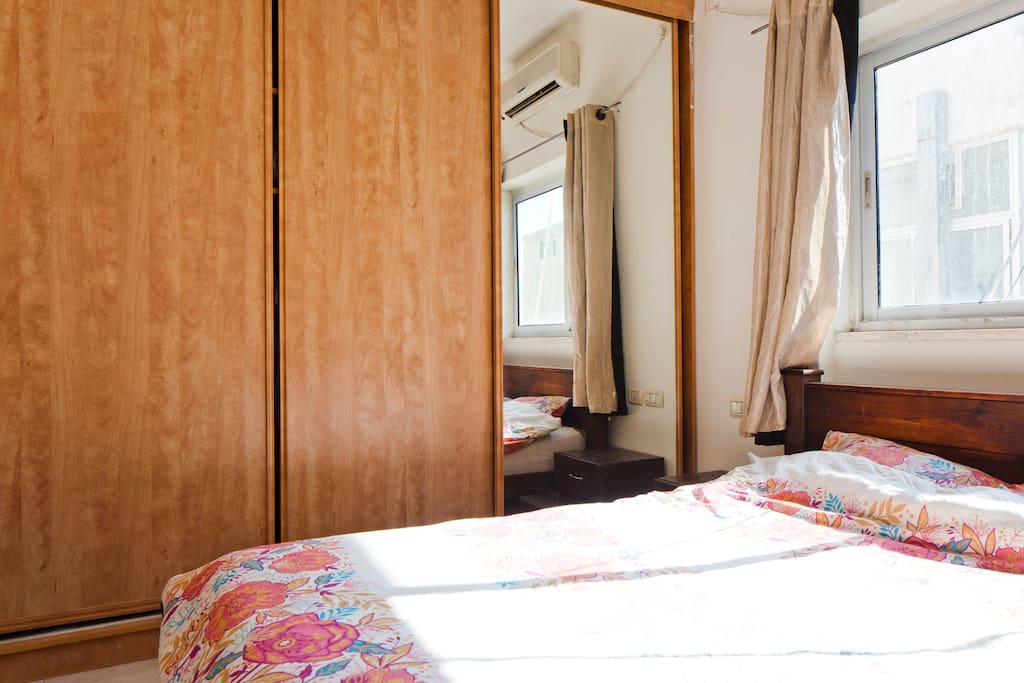 spaceous bedroom with double bed and huge closet full of necessities