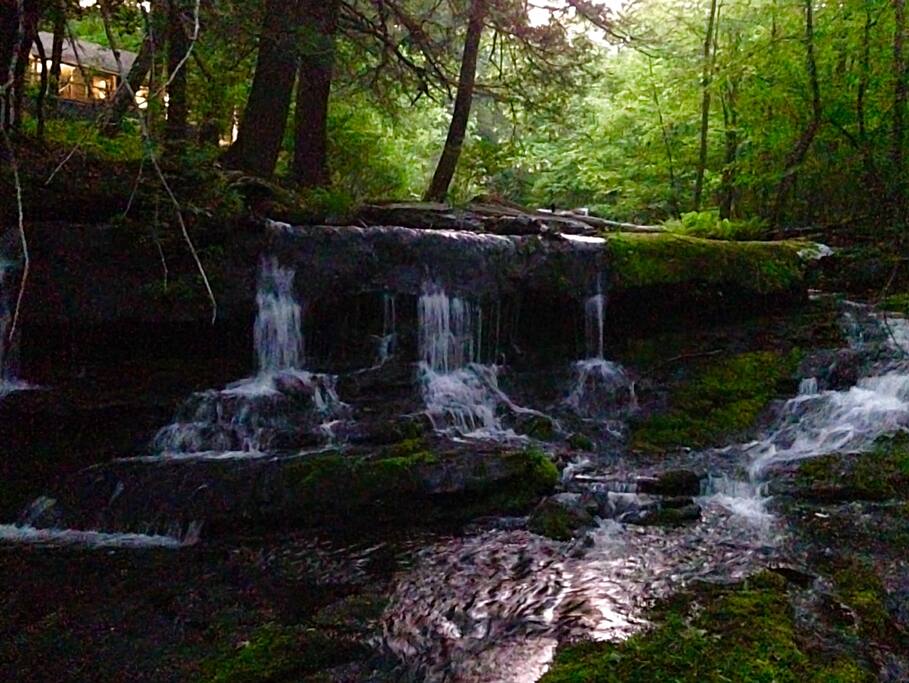 The cabin sits atop a three tiered waterfall.