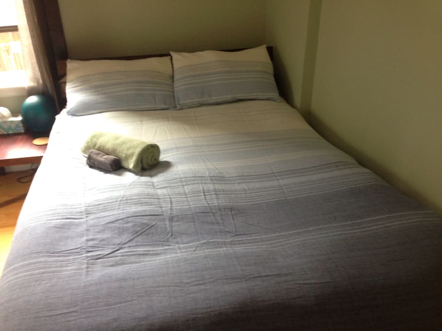Full size bed with cozy linens and memory foam top for a restful stay