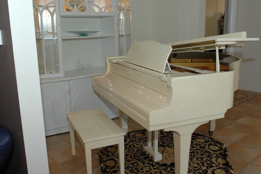 Baby grand piano, to right of hallway