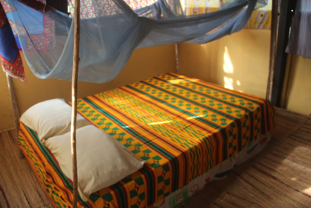 Double bed in top room of treehouse with mozzie net