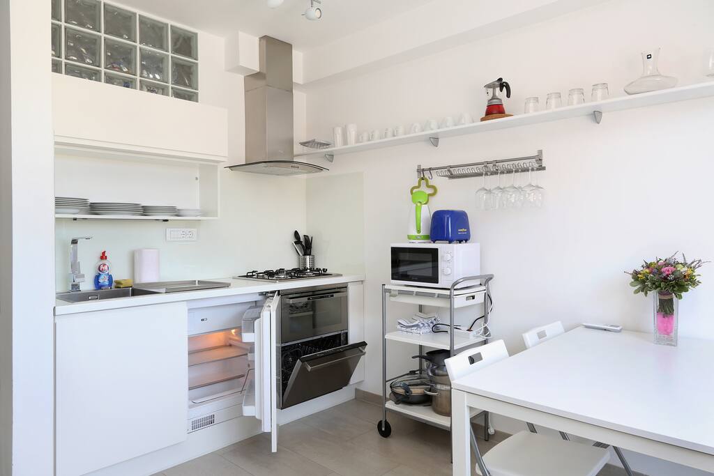 Fully equipped kitchen with dishwasher, oven, microwave, water kettle and toaster.