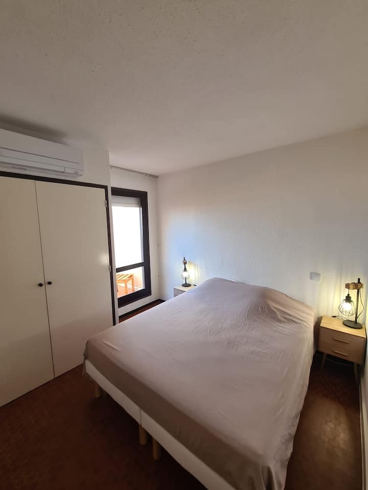 Dormitorio 1 con su cama de 160 cm, su armario amueblado, su TV de 80 cm y su acceso a la terraza que da al lago.
