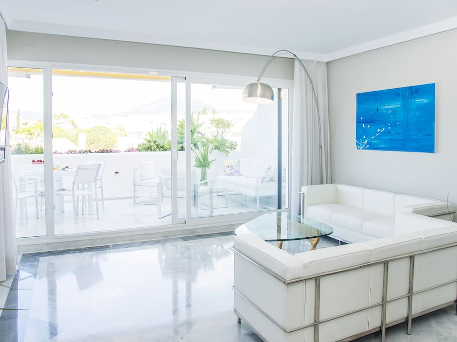 Living room with comfy and modern sofas, next to them TV with international channels