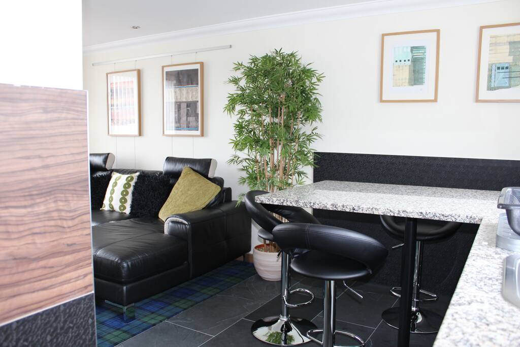 Granite breakfast bar with comfy leather, height adjustable stools.