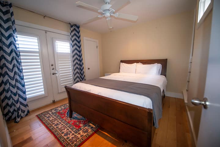 Втора спална соба со брачен кревет и француски врати со отворен балкон на горниот кат. 