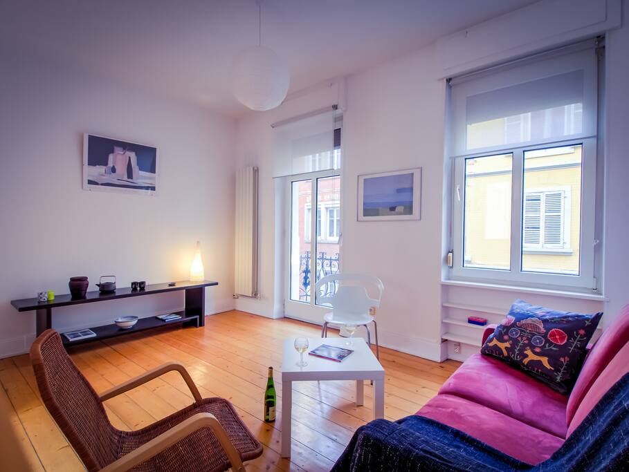 Salon spacieux avec balcon donnant sur une rue à sens unique calme