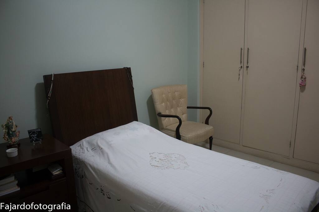 Quarto com uma cama de solteiro.