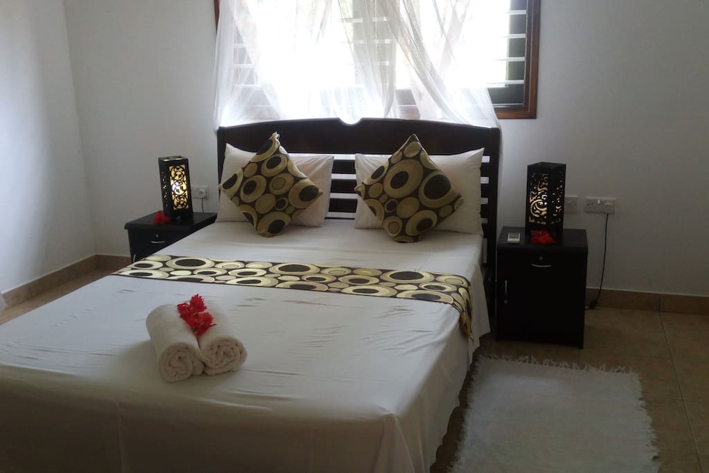 Bedroom features a double bed and an A/C & ceiling fan