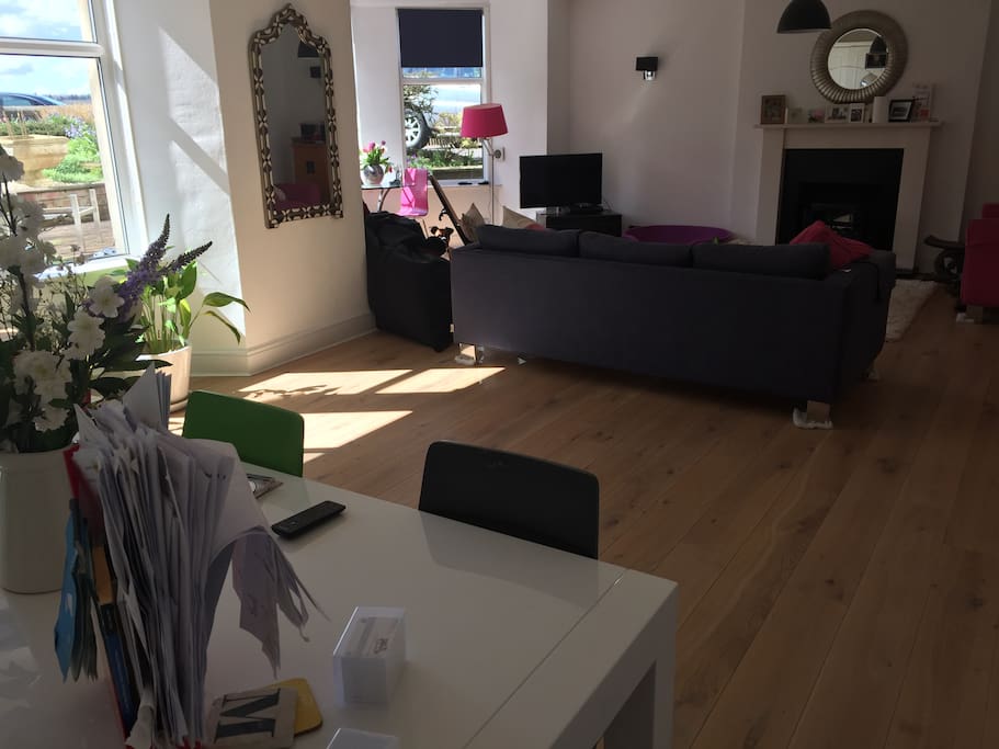 Large living/dining area with log fire place, and french window to garden