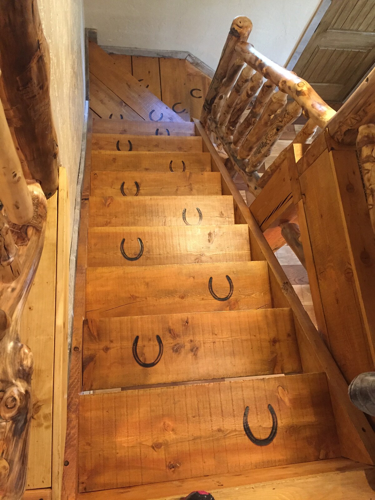 Escalera al área del loft.  ¡Qué lindos son los zapatos de caballo marcados en los escalones de troncos! 