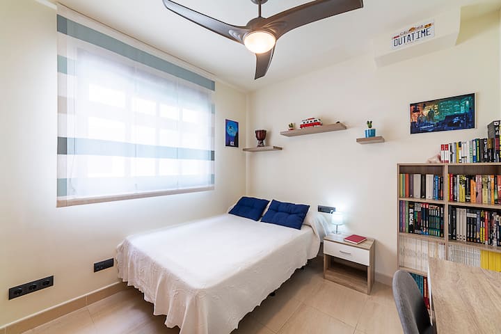 Dormitorio con estanterías con libros y comics.