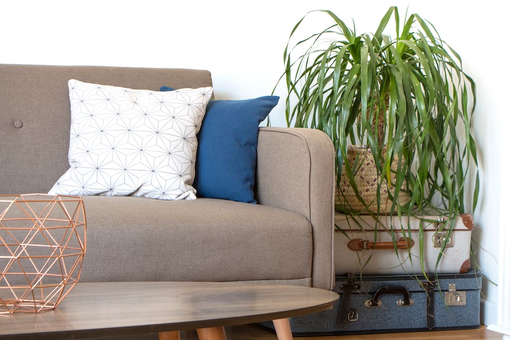 Fold out sofa bed with designer coffee table and vintage suitcases