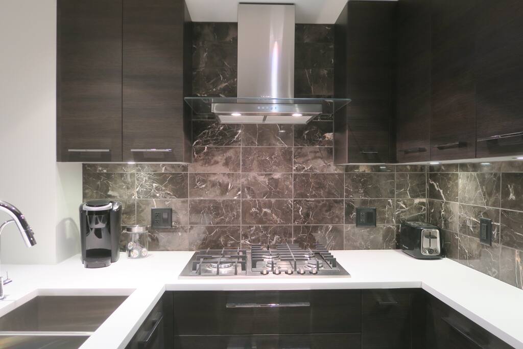 Kitchen: Gas cooktop, marble backsplash.