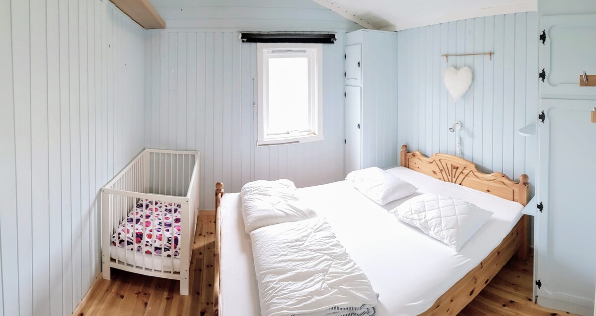 ห้องนอนในอาคารหลักพร้อมเตียงคู่และเตียงเด็กอ่อนพร้อมให้บริการ