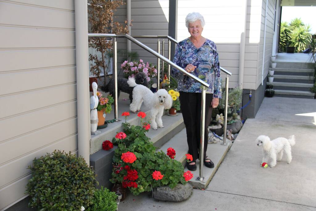 Host with two poodles at front entrance