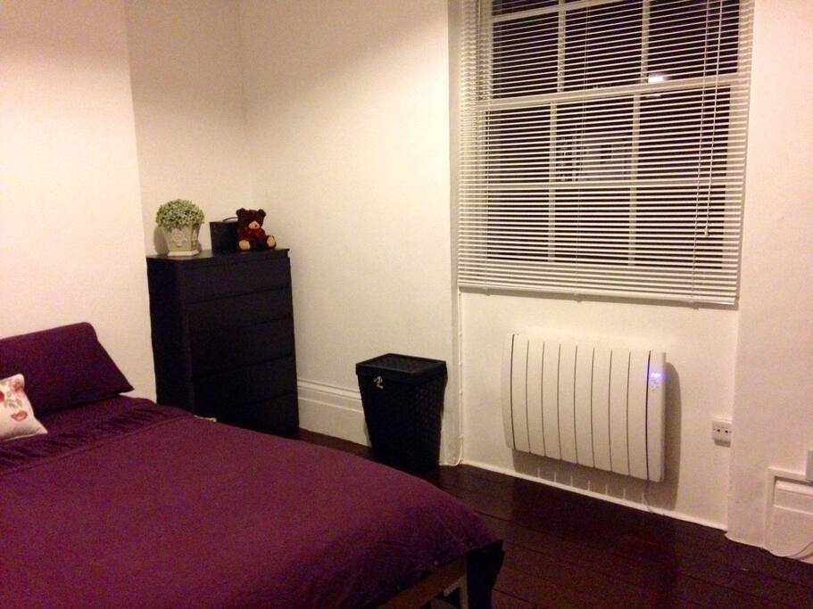 Beautiful and spacious bedroom with high ceiling and wooden floor