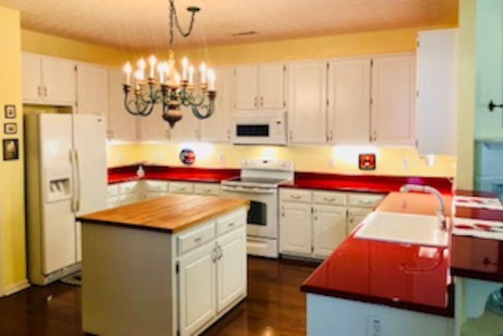 Kitchen with epoxy counters, farmhouse sink, butcher board island and hard wood floor
