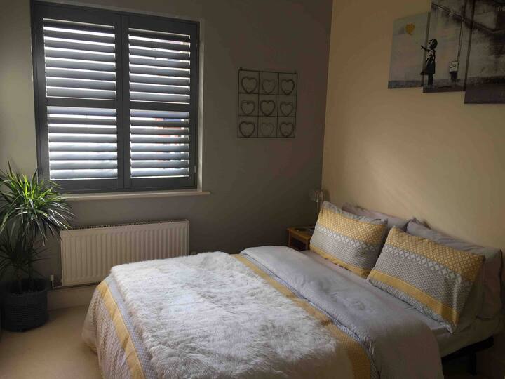 غرفة نوم مريحة مع شبابيك مصنوعة يدويًا عالية الجودة وسرير مزدوج وكرسي أصفر غير تقليدي مستوحى من إيمز وخزانة ملابس كبيرة مع وفرة من المساحة المعلقة والشماعات الخشبية والرفوف الداخلية. مجفف شعر جديد تمامًا وعباءات ملابس بيضاء ومروحة كروم