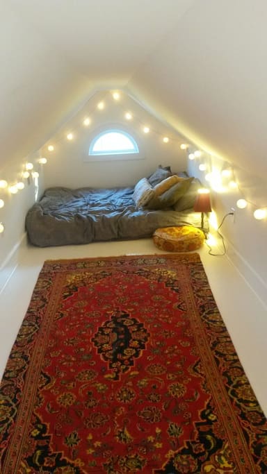 Cozy queen mattress in boho loft area.