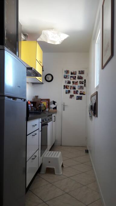 La cuisine équipée d'un frigo, un four et des plaques à induction.
