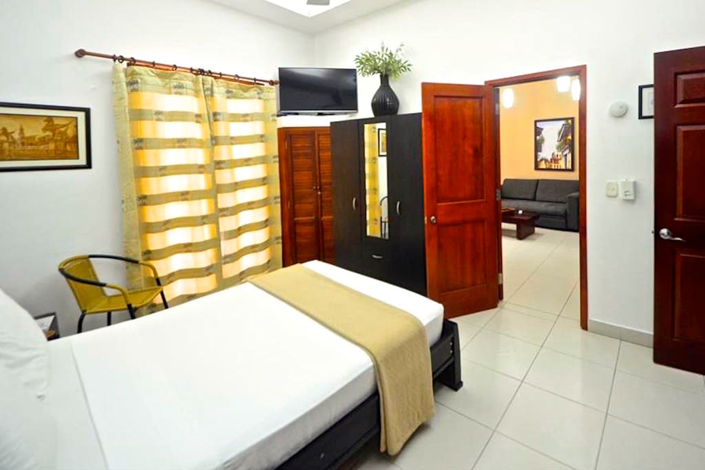 Bedroom #1 with balcony overlooking Calle de la Moneda (curtains closed); door to living area.