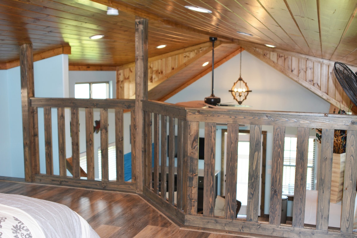 Погледот од поткровјето е еден од најубавите и најмирните во куќата.  Големиот стол со буре е одлично место за читање книга.  Боите на оваа слика точно ги одразуваат вистинските бои на извалканото дрво.