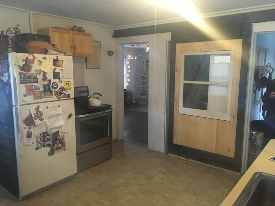 Kitchen with sliding barn door to access upstairs