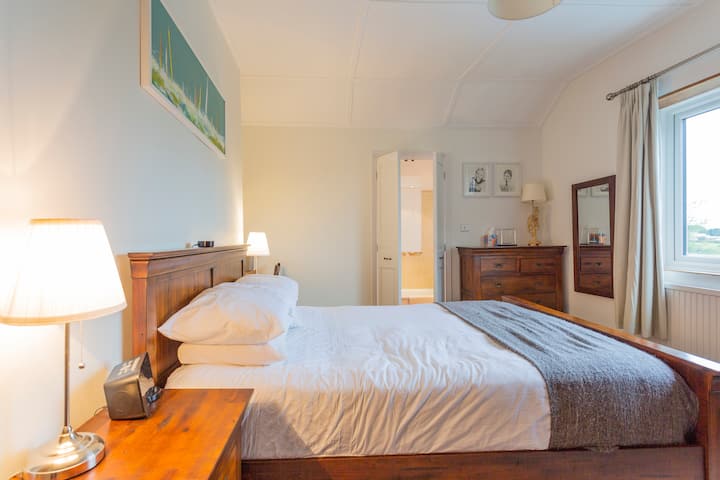 غرفة نوم رئيسية بسرير بمقاس كبير وحمام داخلي