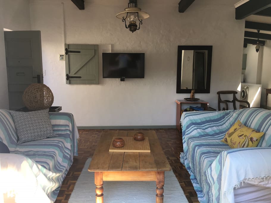 Living area including smart TV (streaming facilities linked to fibre - you can watch anything), leads onto private patio and into communal garden/pool area.