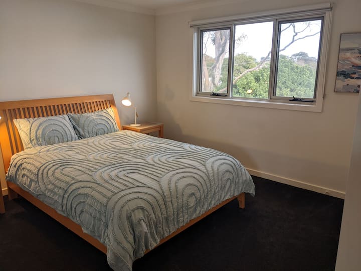 غرفة نوم بسرير بحجم كبير في الطابق العلوي