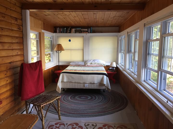 غرفة نوم في الطابق السفلي بسرير بحجم كبير وإطلالة على البحيرة.