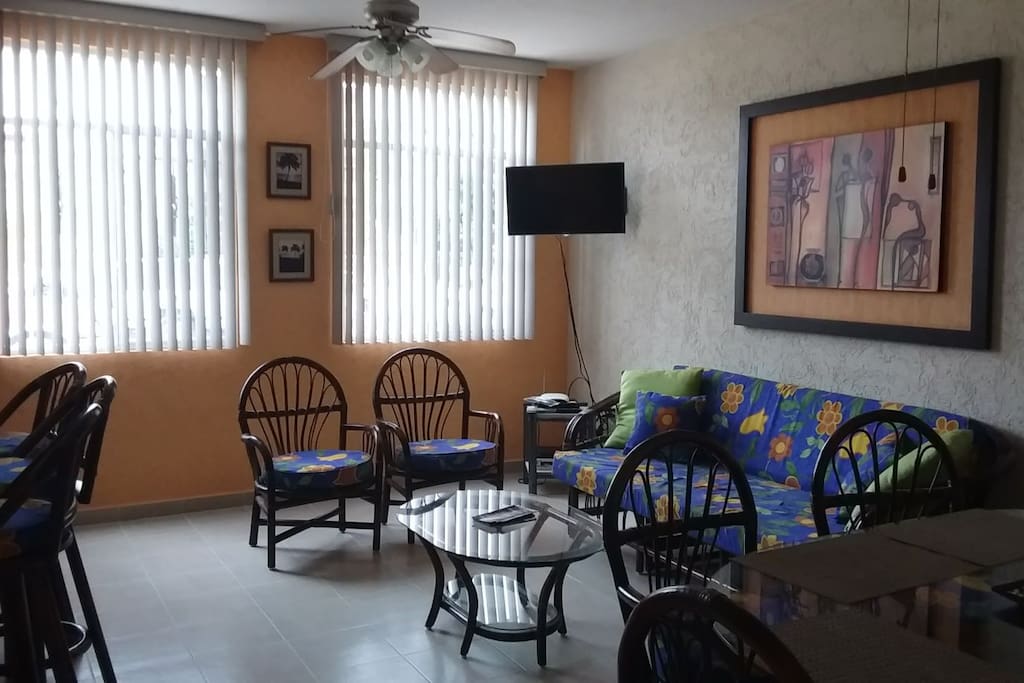 Área de la sala equipada con smart tv y abanico de techo.