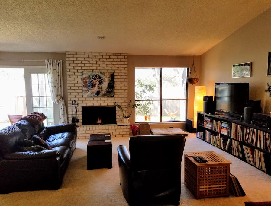 Large living room, opening to the dinning area and to a small patio and green backyard.