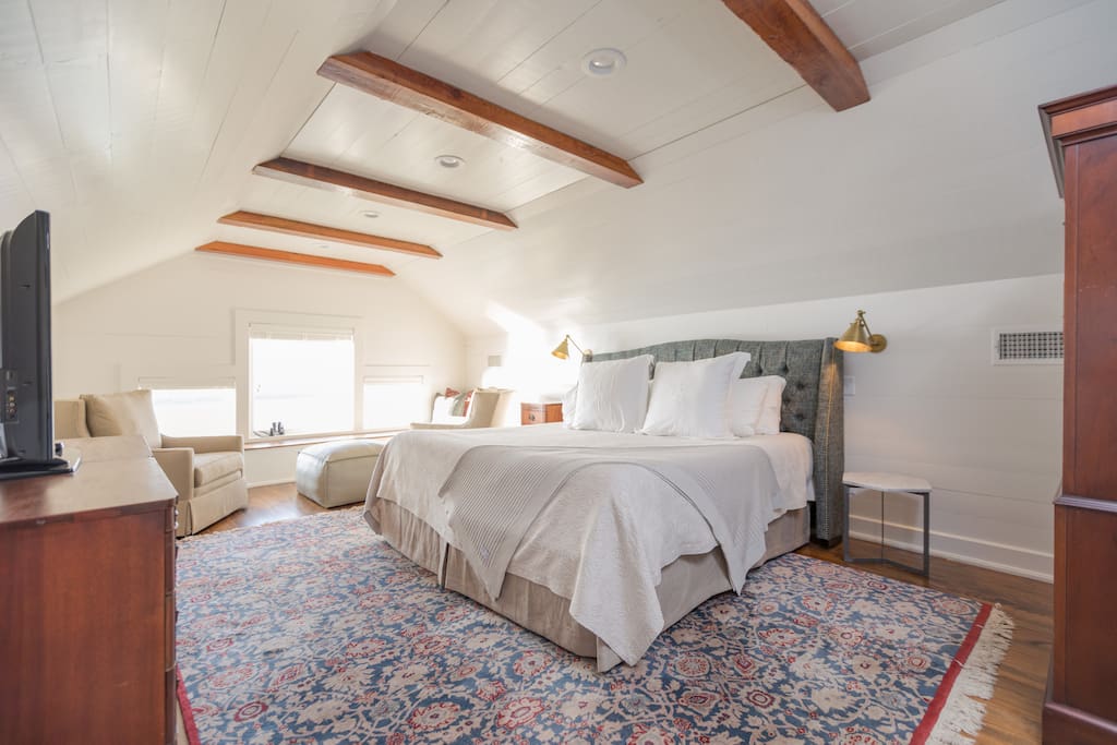 The Observatory Suite's bedroom features a comfortable king-sized bed -- antique furnishings, and a "Netflix Monitor" (TV with Roku).